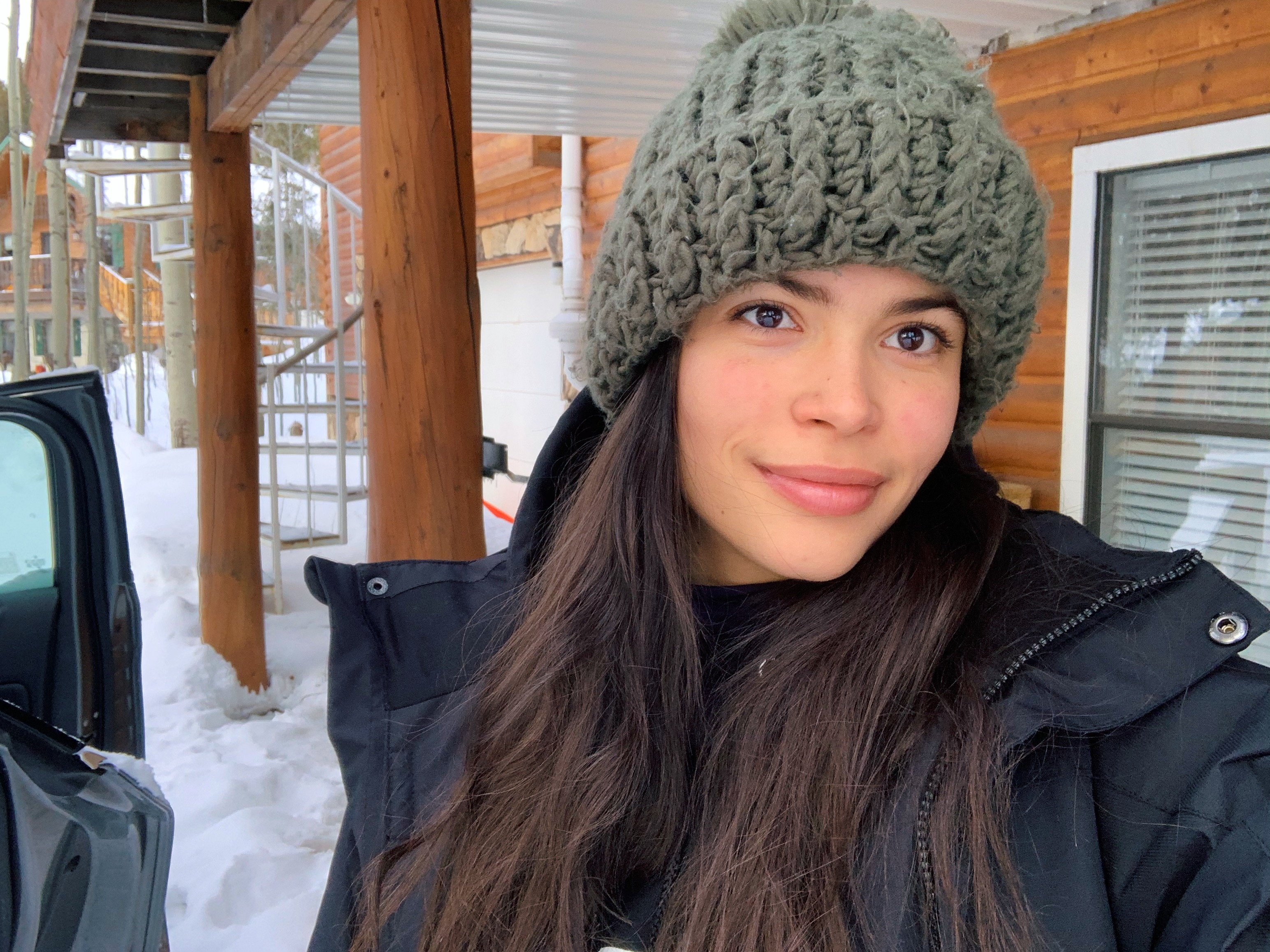 model in emerald green beanie in the snow trip revolve