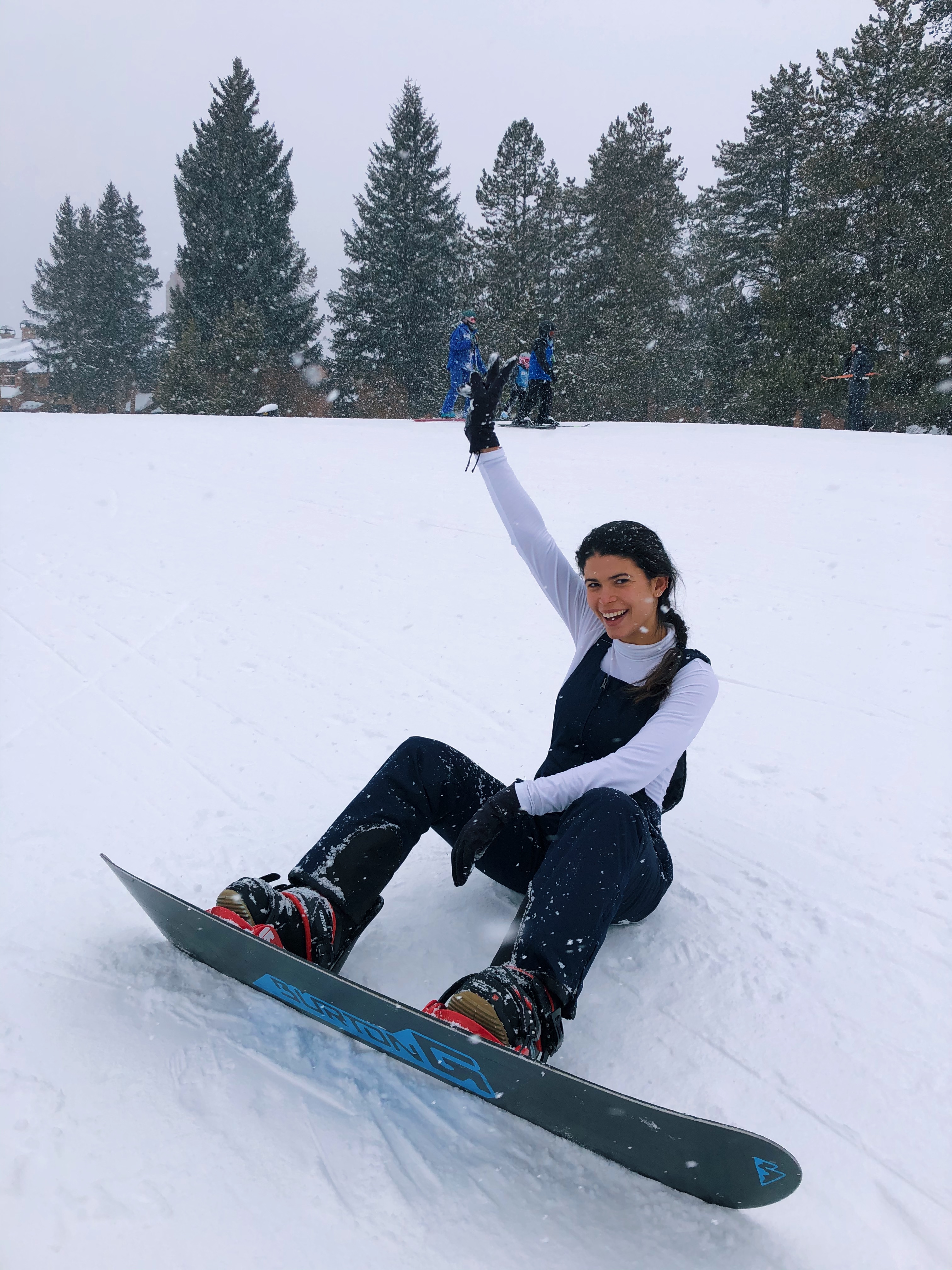 model sitting on the snow snowboard revolve la model